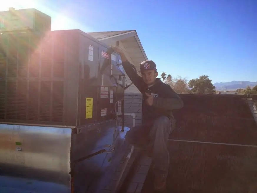 HVAC technician performing Air Duct Cleaning on a rooftop unit in Elizabeth