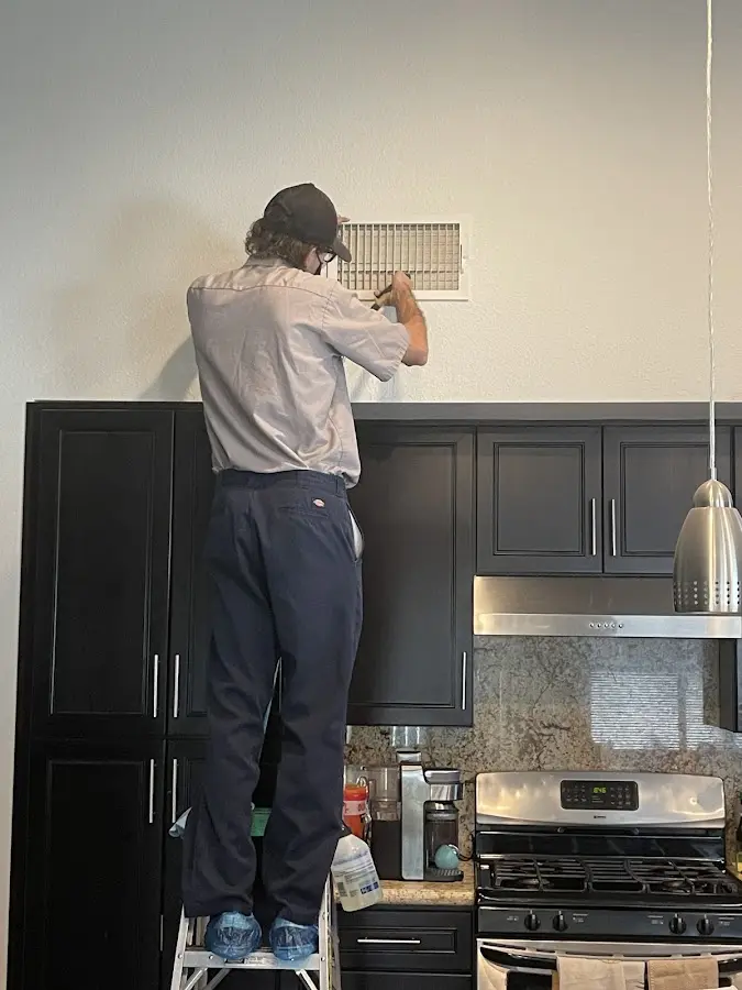 Technician inspecting an air vent during HVAC service in Elizabeth